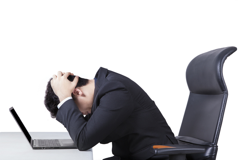 Confused worker with laptop on table